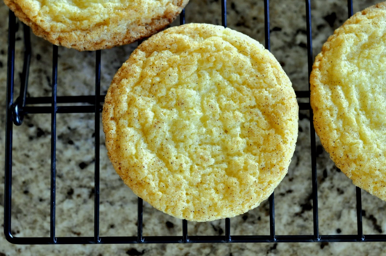 Snickerdoodle cookies cooling on a wire rack. | Taste As You Go
