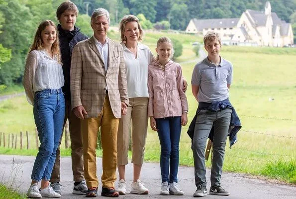 Queen Mathilde, Crown Princess Elisabeth, Prince Gabriel, Princess Eleonore and Queen Paola. beige trench coat white edge trim detail