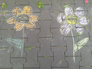 Dwa kolorowe kwiaty narysowane kredą na chodniku