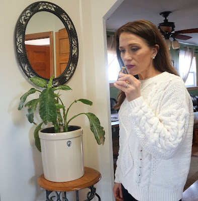 woman smelling a bottle of essential oils