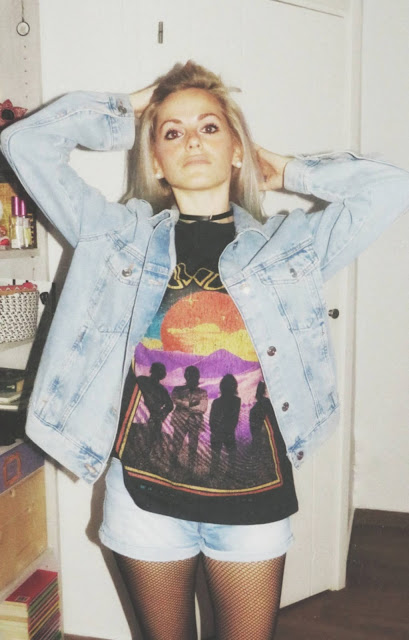 Estilo grunge con camiseta negra ancha con imagen del grupo The Doors, pantalón corto, medias de red pequeña, botas estilo militar y cazadora vaquera