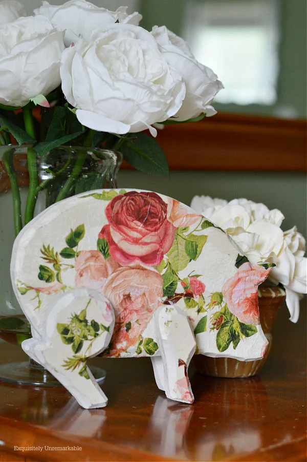 Rose Covered Pig Decor on a dresser with roses
