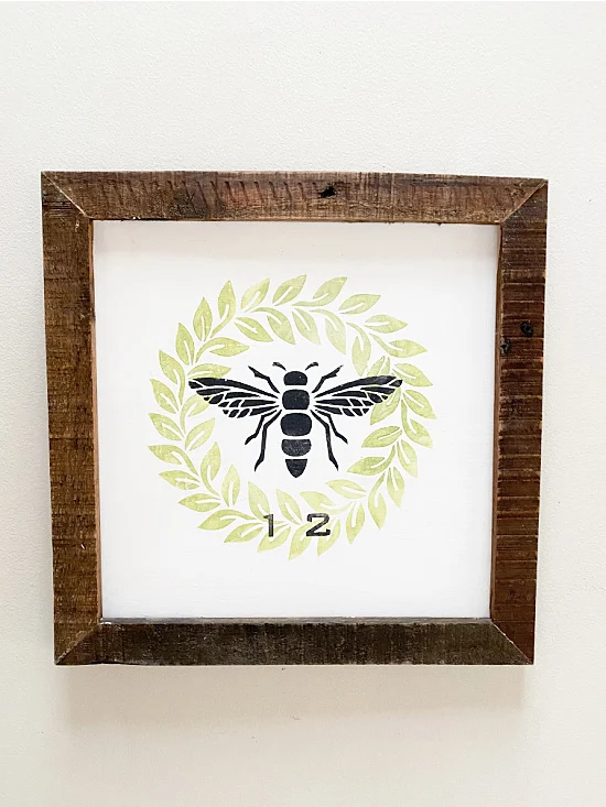 framed wreath and bee sign