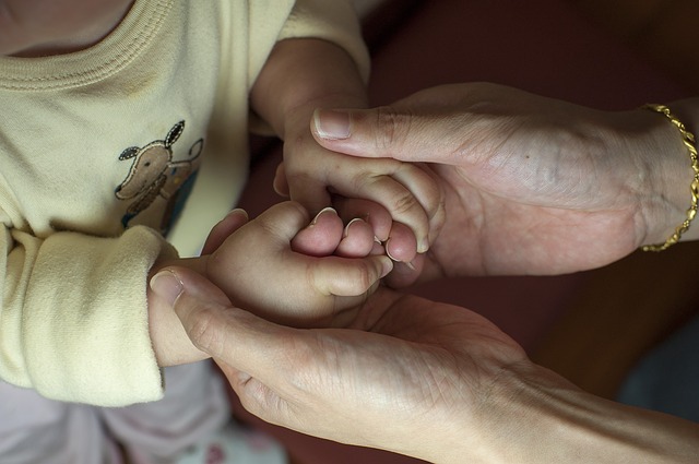 Hände einer Erwachsenen halten Kinderhände