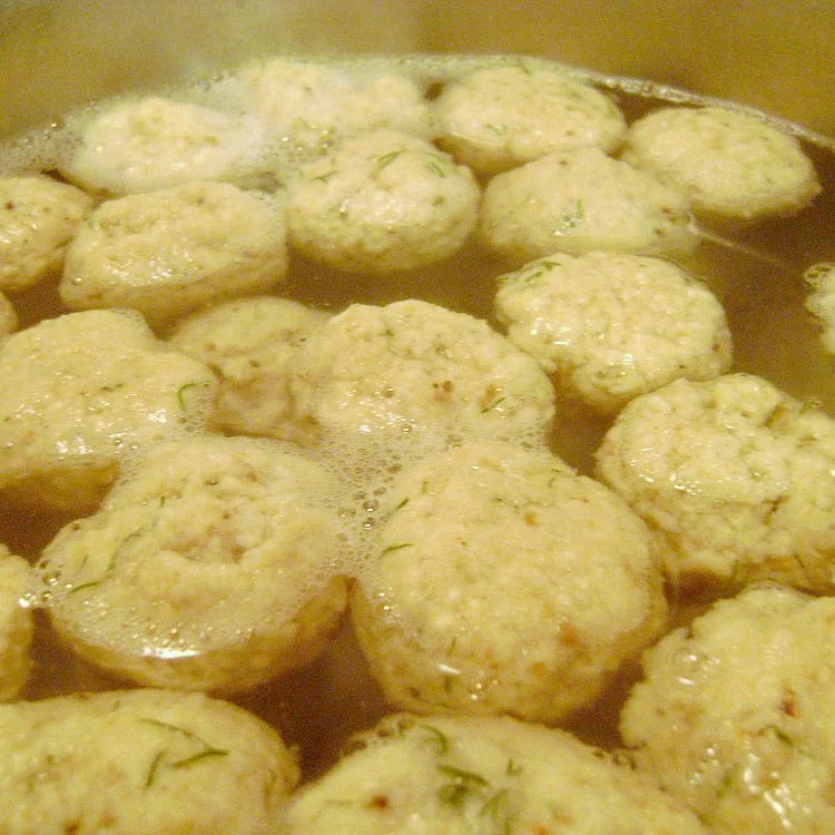 Mini matzo balls boiling in water in a pot for Chicken Soup with Mini Matzo Balls by Renee's Kitchen Adventures