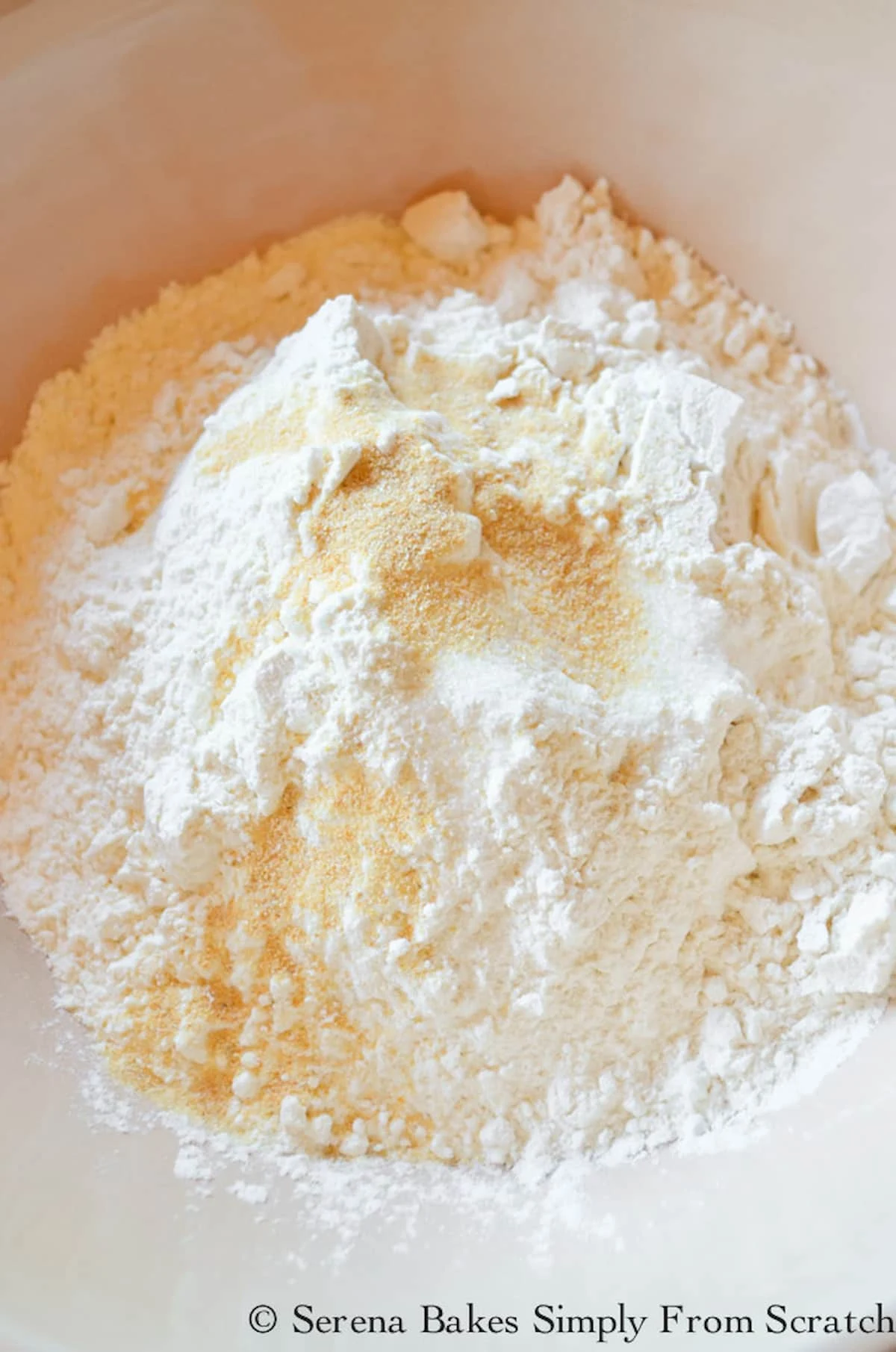 Flour, Baking Powder, Salt and Granulated Garlic in a cream colored bowl.