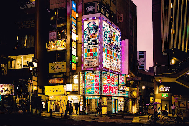 Asian cityscape with lit up neon and LED signs at night.