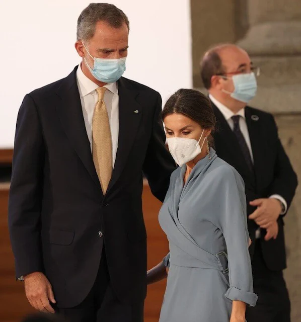 Queen Letizia wore a new wrap around dress by Adolfo Dominguez. Red pumps by Magrit. Earrings by Tous jewelry