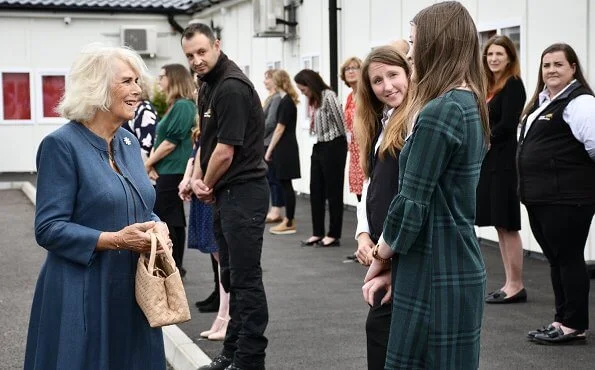 The Duchess of Cornwall wore a denim dress from Fiona Clare, and a neutral handbag and shoes. She wore her FitBit watch and some gold jewellery