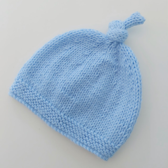 Cute knitted baby hat with topknot