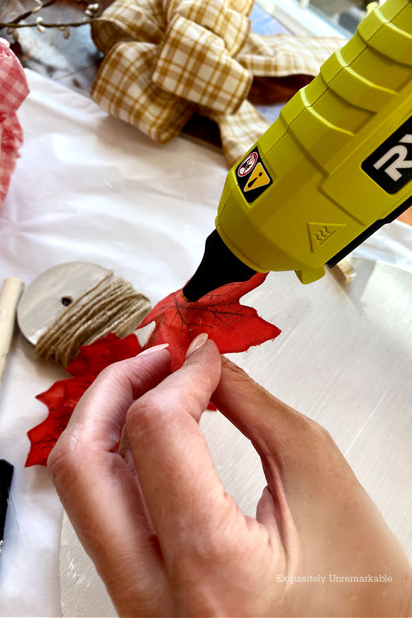 Gluing Fall Leaves to wooden pumpkin