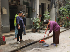woman cleaning up ashes with broom and dustbin