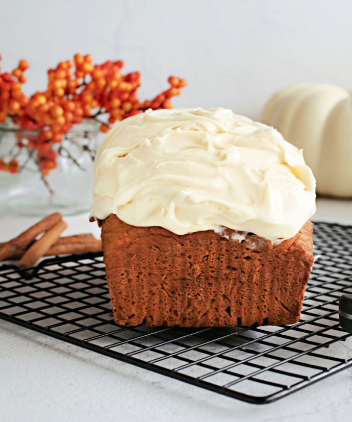 Recipe for a fluffy, flavorful pumpkin loaf cake topped with salted caramel cream cheese frosting.