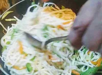 Mixing hakka noodles with spoon and fork for hakka noodles veg recipe