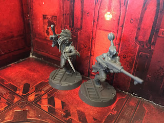 Two Escher gangers sneak through the underhive in Necromunda: Underhive.