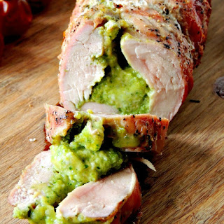 Broccoli Pesto and Cheese Stuffed Grilled Pork Tenderloin on a wooden cutting board.