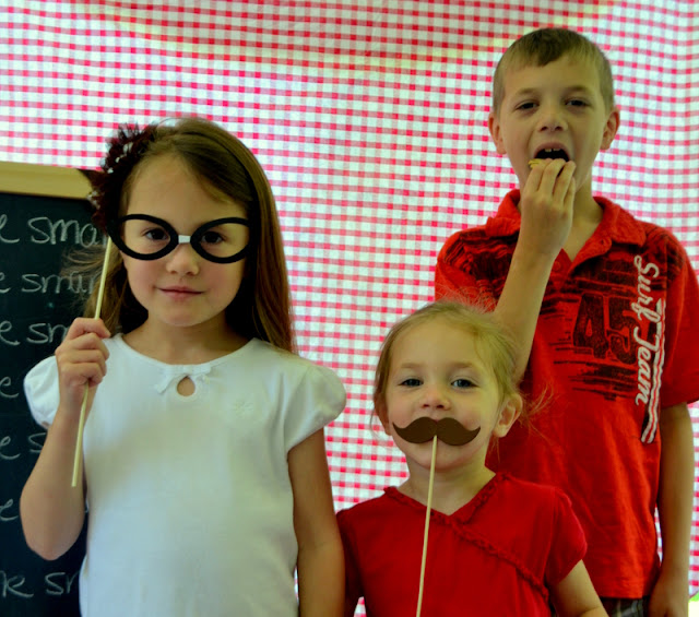 kids using photo booth props, glasses, moustache, photobooth props