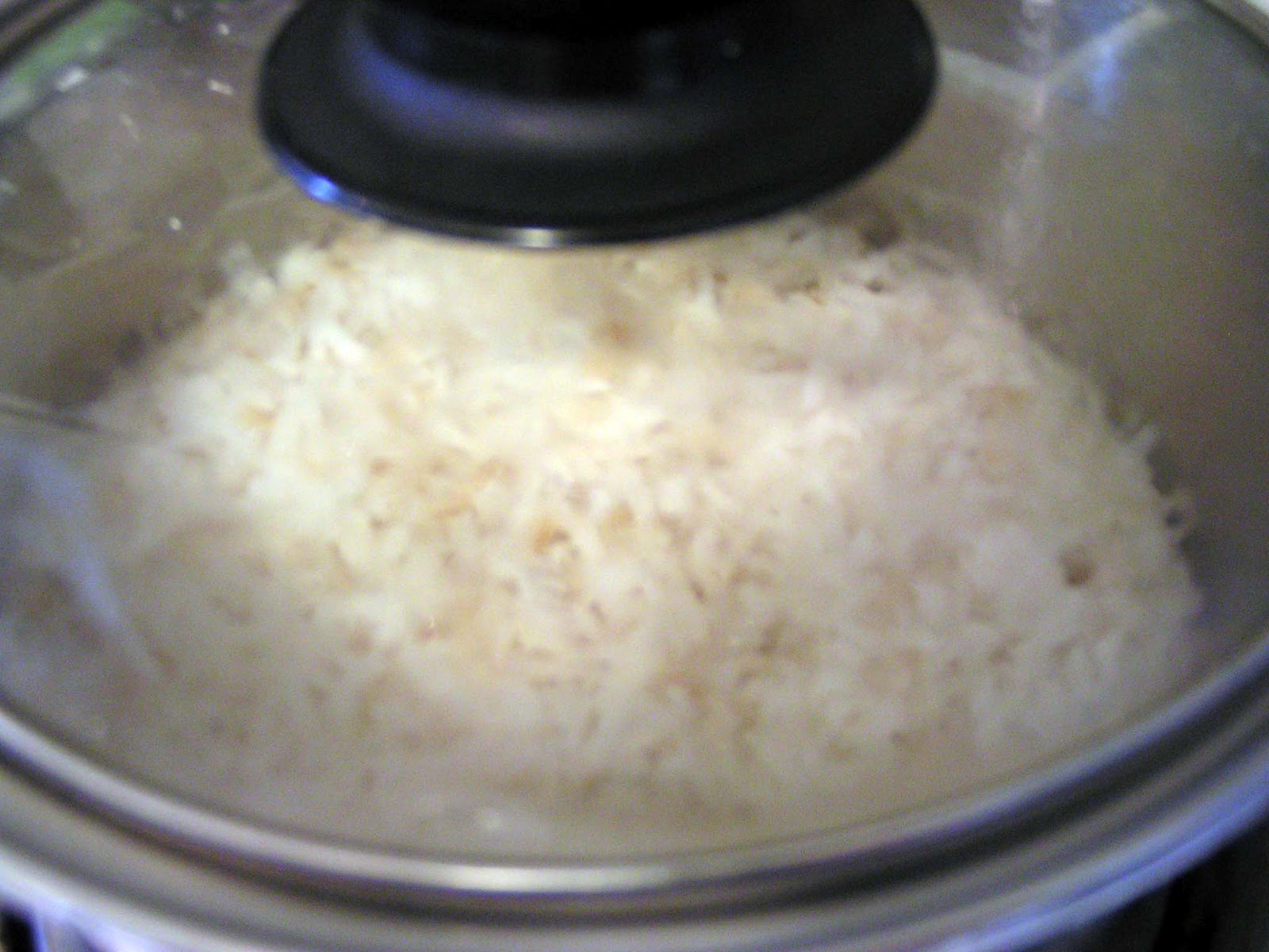Saucepan with rice simmering on low heat, covered.