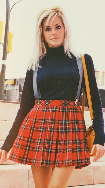 Alejandra Colomera vestida con jersey azul, falda roja cuadros escoceses, tirantes en color gris, calcetas gris y zapatos estilo colegial negro