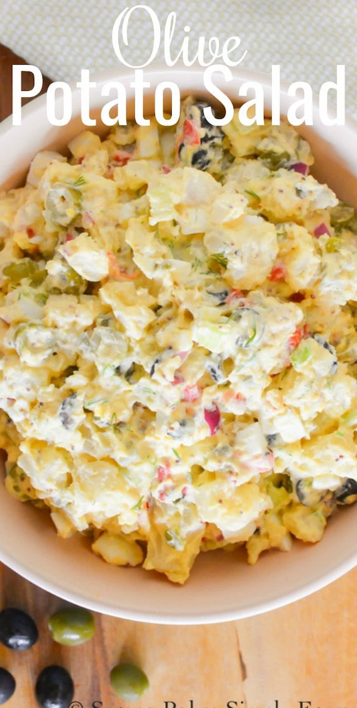 A bowl of Potato Salad with Black and Green Olives in a tangy potato salad dressing.