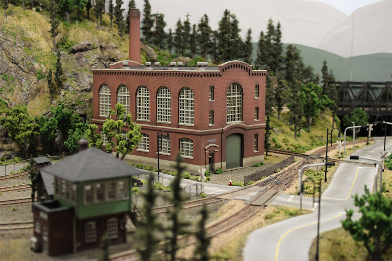 A completed Northern Light & Power Co. kit placed beside railroad tracks in an industrial scene