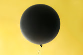 Black balloon on yellow background