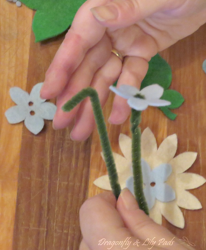 Threading the Center of the flowers which look like buttons to hold the flowers together.