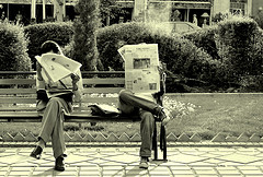 Untitled photograph of two people reading newspapers on a park bench by Hamed Saber on Flickr