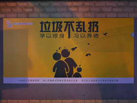"don't litter" ("垃圾不乱扔 学以修身 习以养德") sign displaying objects being thrown, apparently in the direction of a family in Hongkou, Shanghai