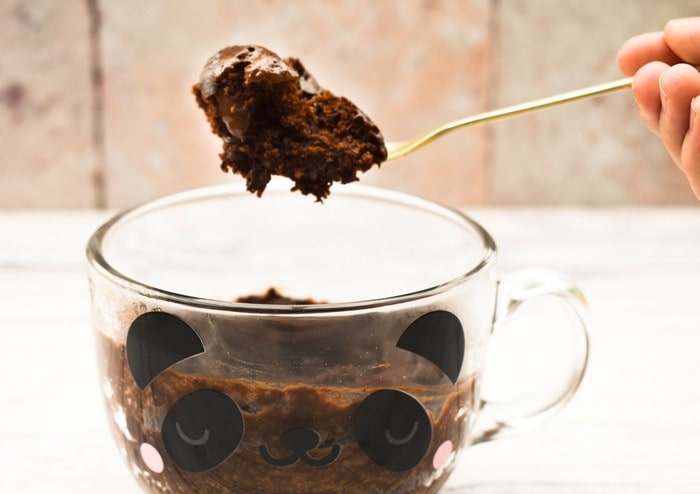 A spoonful of chocolate brownie lifted out of the mug