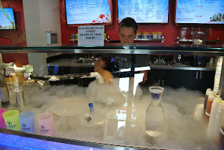 A person behind a food bar.