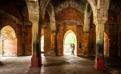 Interior de la Mezquita de las Nueve Cúpulas, en Bangladesh. En una de sus puertas se encuentra una persona con una cámara fotográfica en un trípode