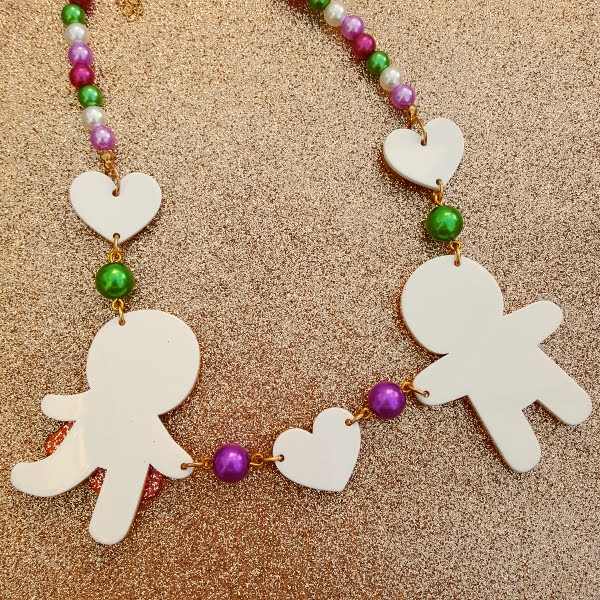 back of acrylic gingerbread necklace on glitter backdrop