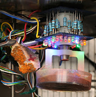 Complicated electronic machine with arrays of LEDs in different colors, shining onto a sample of simulated Martian soil.