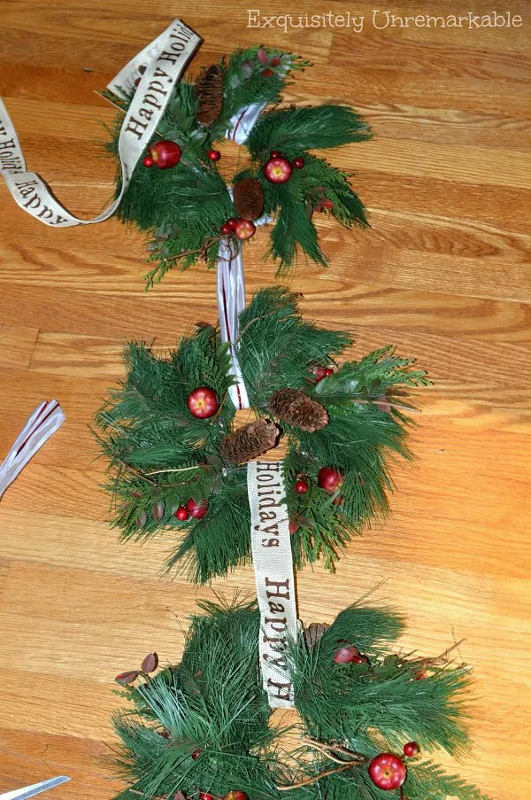 Three wreaths on the floor getting connecting ribbon replaced