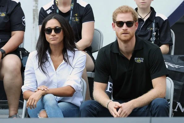 Prince Harry and Meghan Markle watched Wheelchair Tennis match. Style of Meghan Markle. wore a ice blue blouse and jeans