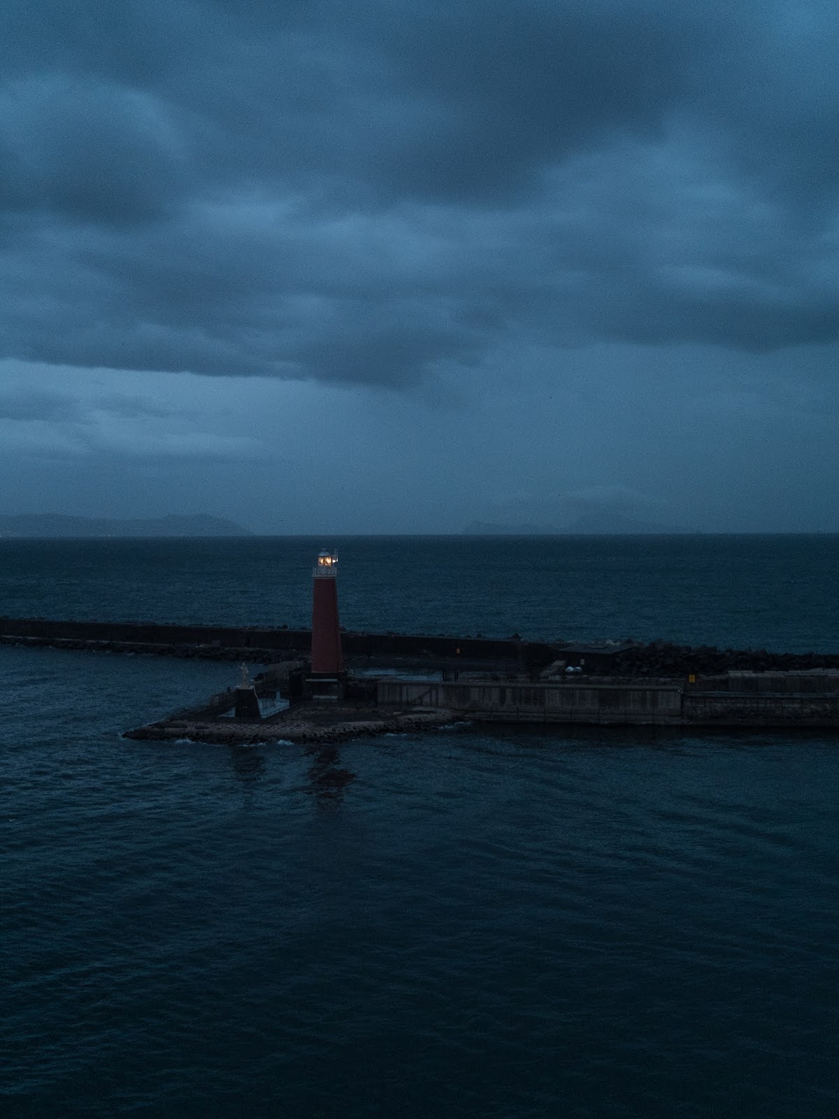 The lighthouse on Molo di San Vincenzo in the port of Naples at dawn