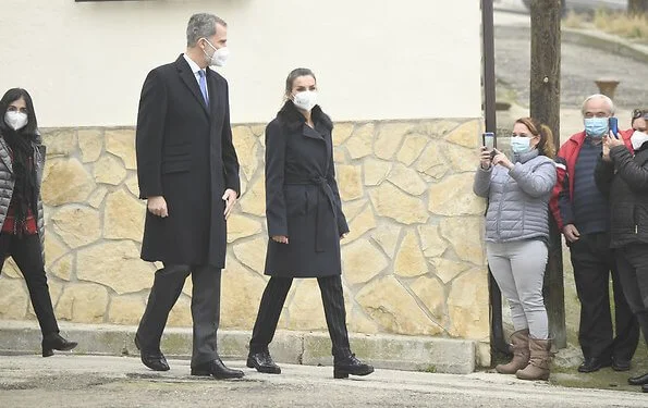 Queen Letizia wore a Canika wool with wrap belt coat from Hugo Boss, and stripe navy trousers and blazer from Boss, and oxford shoes from Uterque