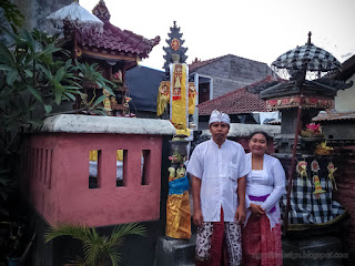 Happy Couple Celebrating Galungan Holiday In Front Of Small Balinese Hindu Temple In The House