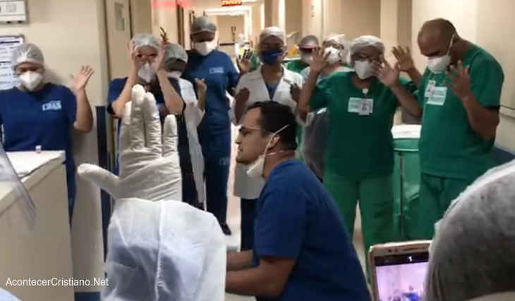 Médico orando en hospital con enfermeros