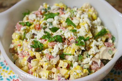 A corn salad made in the tradition of Mexican Street Corn on the Cob, with fresh cooked corn and dressed with a mayo and sour cream mixture of Cotija cheese, chili powder, cilantro, lime juice and zest. Toss in some crisp veggies, chill well and garnish with a little more cheese and cilantro.