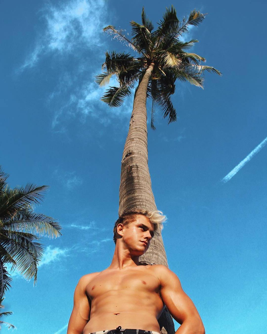 cute-slim-fit-bare-chest-blond-twink-palm-tree
