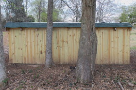 privacy fence panels used as the back of the goat shelter