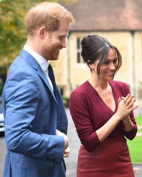 Meghan Markle wore Joseph pullover, Hugo Boss Selrita leather skirt, Sarah Flint pumps and Emily Mortimer Hera gold and diamond earrings