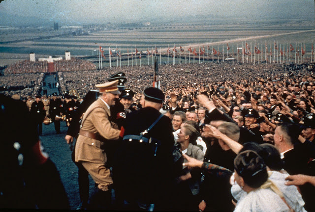 1937 год, Германия. Воодушевленные немцы приветствуют Адольфа Гитлера на празднике урожая в День благодарения. / Adolf Hitler greets the cheering throng at a rally in 1937. Nazi German Fuhrer Adolf Hitler celebrating Harvest Day festival. Massive crowd of adoring Germans pressing forward to greet their idol.
