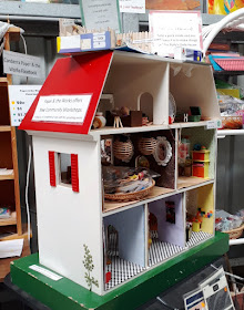 Child's wooden dolls' house filled with home-made furnishings.