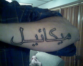 Guy with some Arabic Text Tattoo design on his forearms