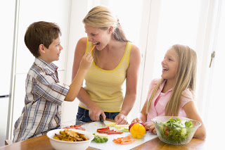 Mother preparing healthy foods with son and daughter