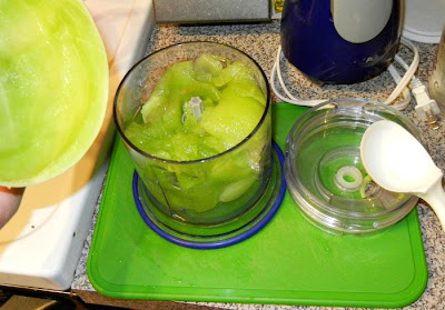 ingredients in a food processers on a green cutting board 