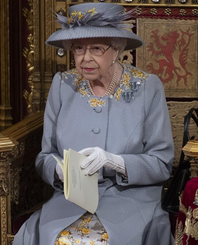 Queen Elizabeth wore a grey jacquard coat with lemon flowers, and a grey and yellow silk dress, and hat by Angela Kelly